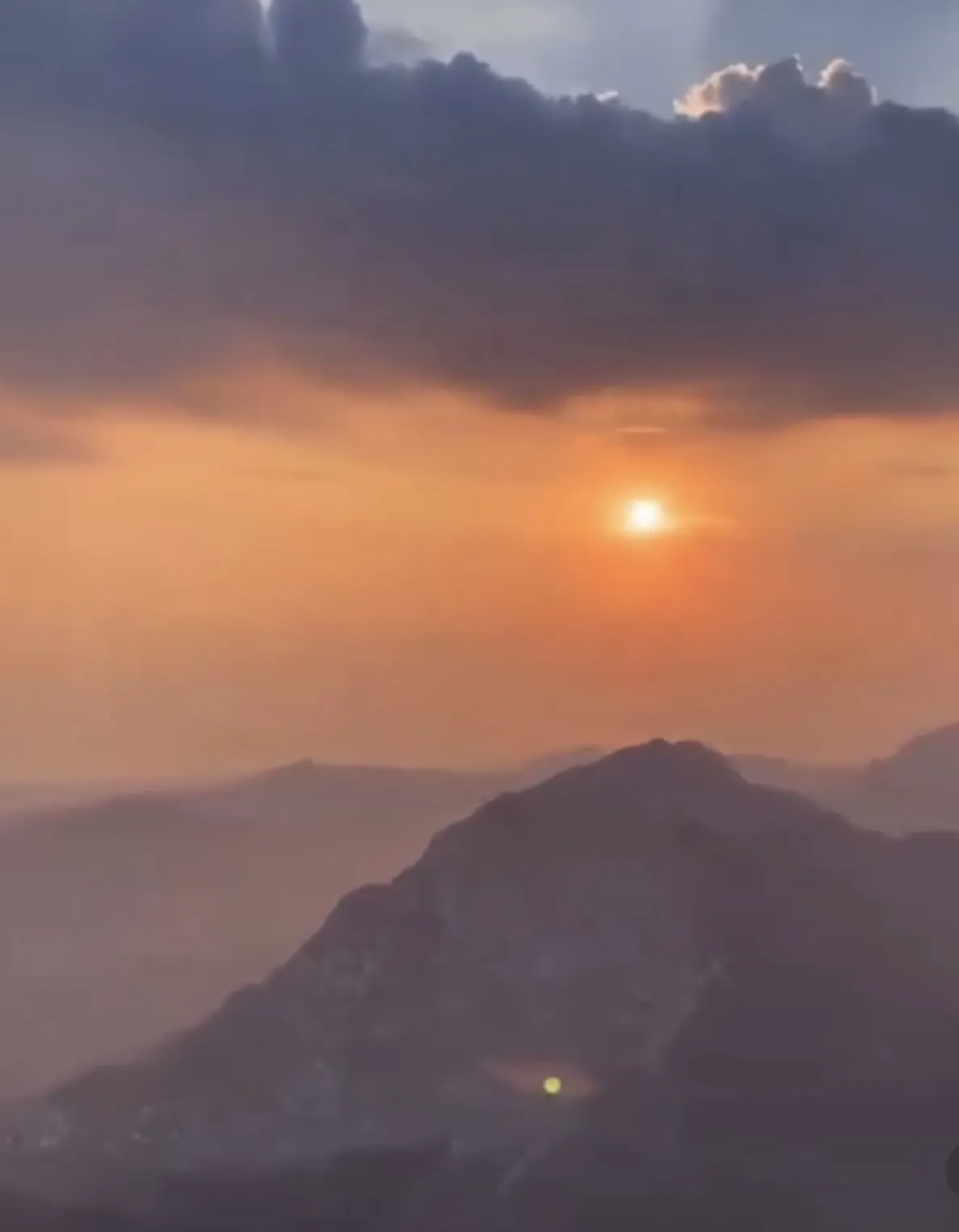 De zon boven een bergkam in oranje ochtendlicht